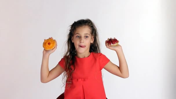 Meisje maken keuze twee taarten — Stockvideo