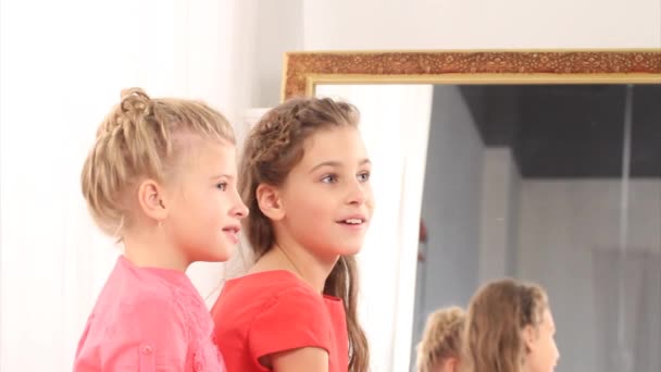 Две удивленные девушки у зеркала — стоковое видео