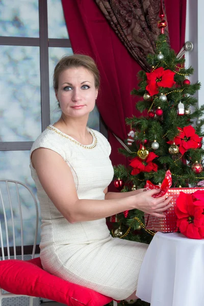 Femme avec boîte cadeau sous l'arbre à la maison — Photo