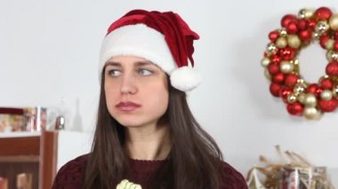 Noel Baba şapkalı kız kek yiyor