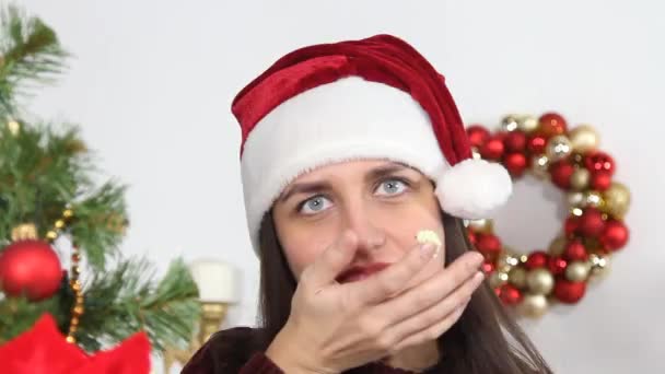 Girl in Santa hat eats cupcake — Stock Video