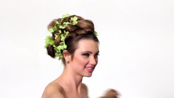 Hermosa mujer con flor de orquídea en el pelo posando — Vídeo de stock