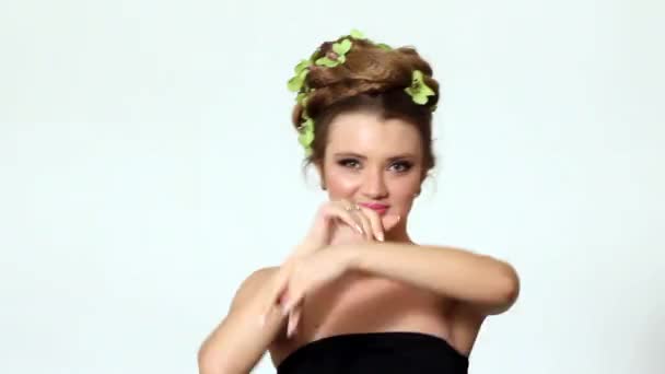 Hermosa mujer con flor de orquídea en el pelo posando — Vídeo de stock