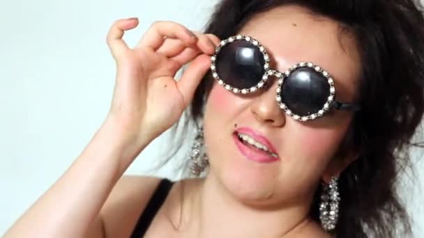 Толстая женщина позирует в очках с жвачкой — стоковое видео