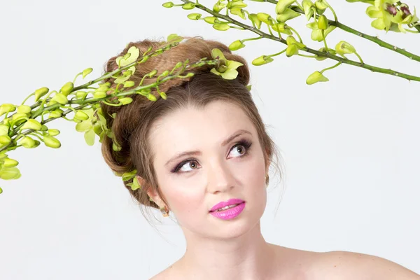 Mooie vrouw met orchideebloem in haar — Stockfoto