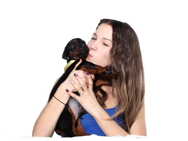 Girl kissing her doberman puppy — Stock Photo, Image