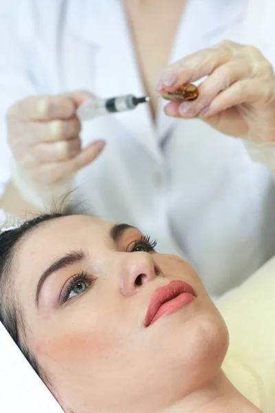 Hand with a syringe over the face — Stock Photo, Image