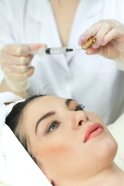 Hand with a syringe over the face — Stock Photo, Image