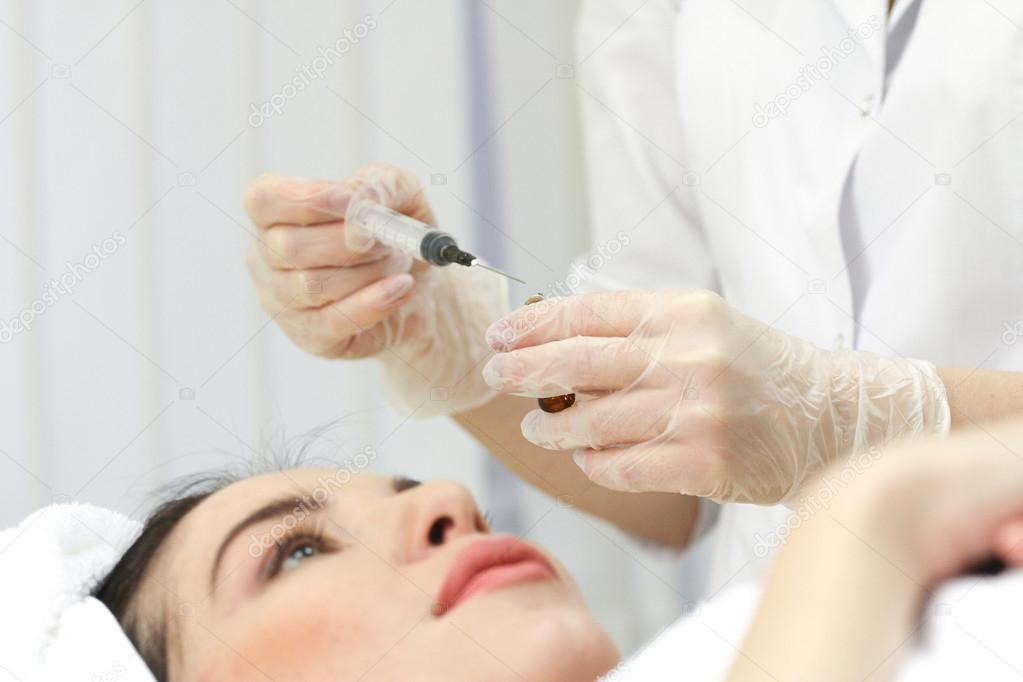 Hand with a syringe over the face