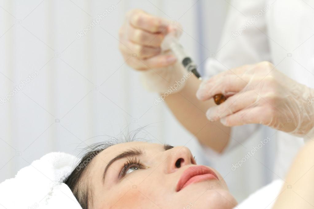 Hand with a syringe over the face