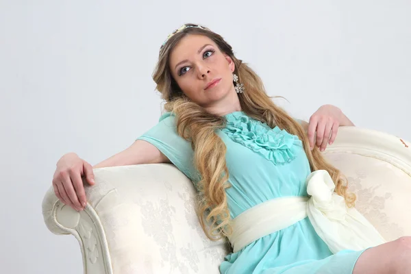 Pretty young woman leaned back on white sofa — Stock Photo, Image