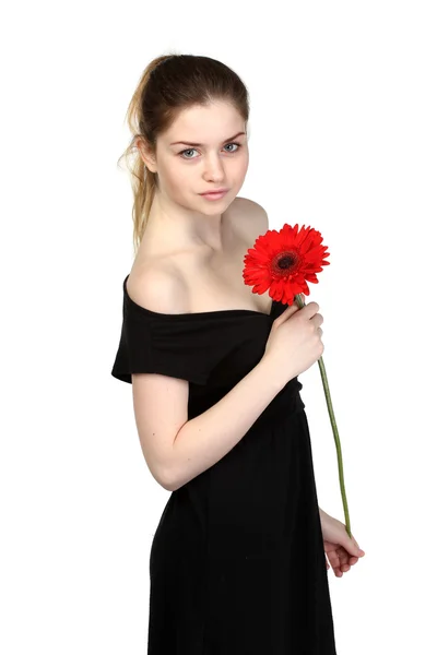 Hermosa chica con flor en vestido negro — Foto de Stock