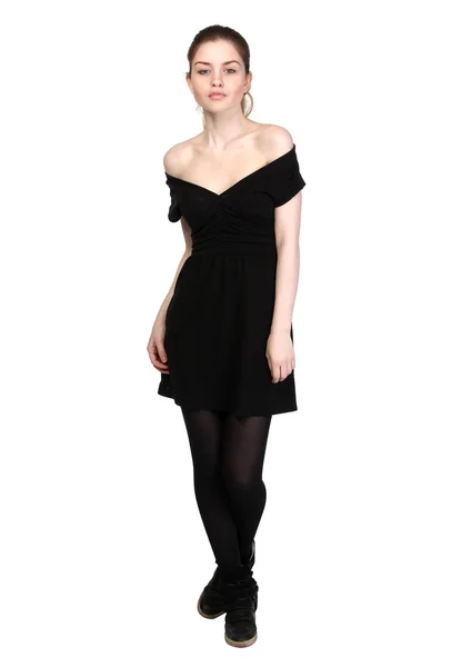Молодая девушка, одетая в черное платье и черные кроссовки — стоковое фото