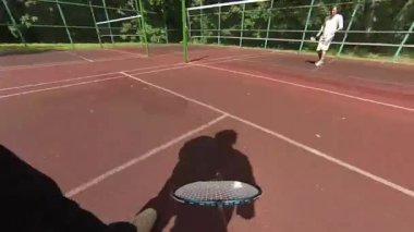 iki adam sahada badminton oynarken