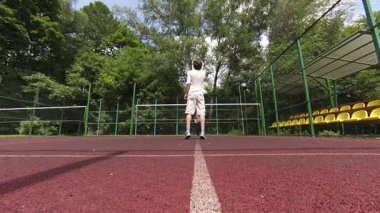 iki adam sahada badminton oynarken