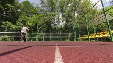 iki adam sahada badminton oynarken