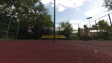 iki adam sahada badminton oynarken