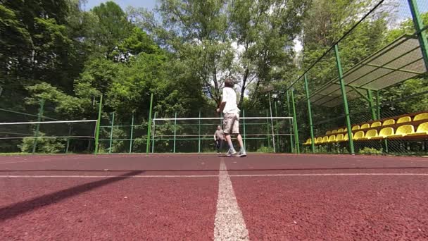 Zwei Männer spielen Badminton auf dem Platz — Stockvideo
