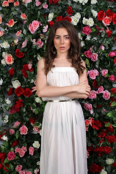 Mädchen in weißem Kleid auf floralem Hintergrund — Stockfoto