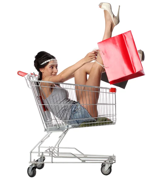 かなりブルネットの女性は s で空ショッピング トロリーに座っています。 — ストック写真