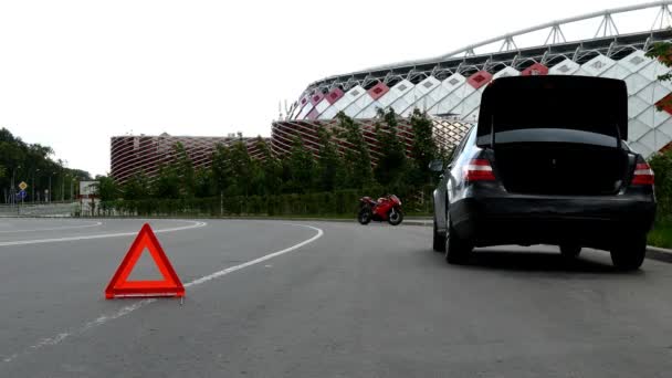 Rode gevarendriehoek met een afgebroken auto en motorfiets — Stockvideo