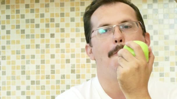Homem adulto comendo uma maçã verde com prazer . — Vídeo de Stock