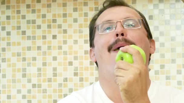 Hombre adulto comiendo una manzana verde con placer . — Vídeos de Stock