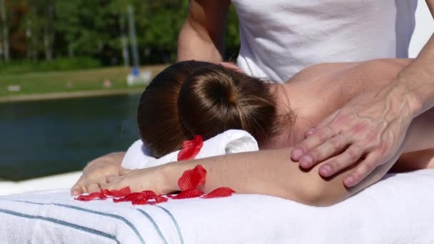 Donna caucasica sdraiata su un tavolo da massaggio all'aperto — Video Stock