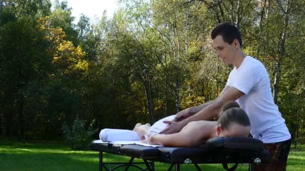 Fizioterapeuta kezelése a hátán a beteg — Stock videók