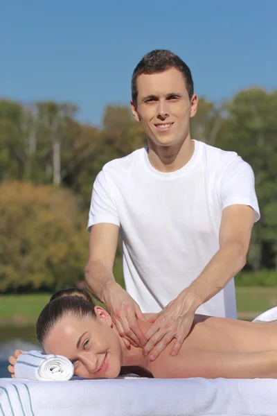 Mannen att ge massage till ung brunett utomhus — Stockfoto