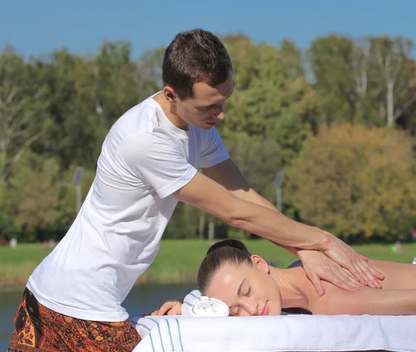 Man giving massage to young brunette outdoors — Stock Photo, Image