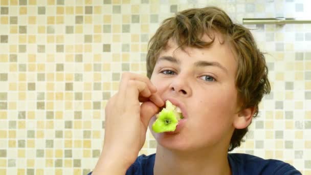 Счастливый ребенок ест зеленое яблоко с удовольствием . — стоковое видео