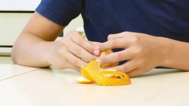 Boy cleans tangerine — Stock Video