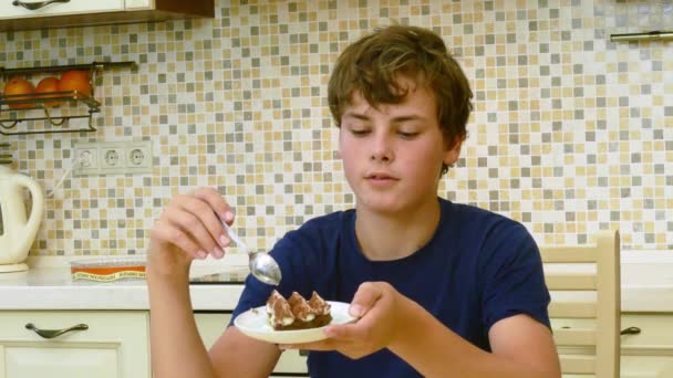 Gelukkig tiener eten voor het dessert aan de eettafel — Stockvideo