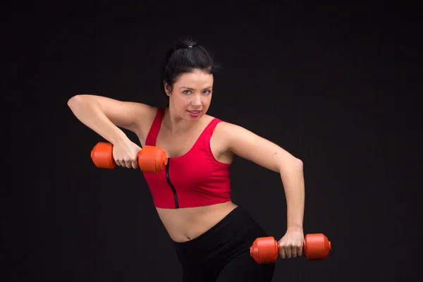 Brutální atletická žena pumpování do svalů s činkami — Stock fotografie