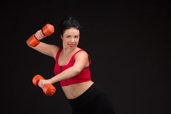 Brutální atletická žena pumpování do svalů s činkami — Stock fotografie