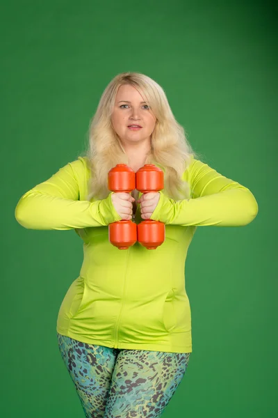 Plus velikost ženy se muscules s činkami zelené zádech čerpání — Stock fotografie