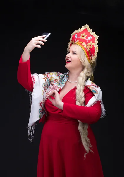 Девушка, стоящая в русском традиционном костюме с мобильного телефона — стоковое фото