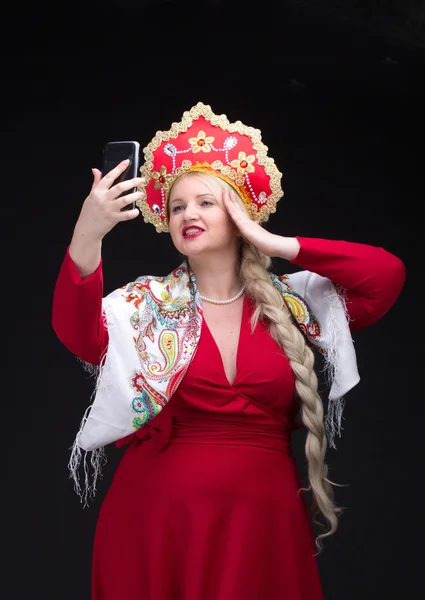 Menina de pé em traje tradicional russo com telefone móvel — Fotografia de Stock