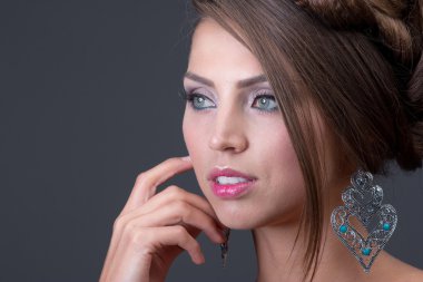 Woman wearing shiny blue earring clipart