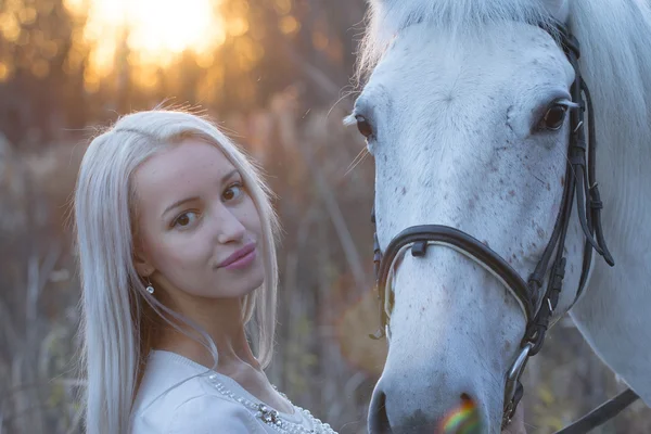 Blondynka i białego konia patrząc sobie w oczy — Zdjęcie stockowe