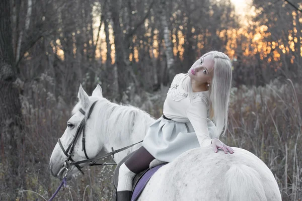 Twee blonde, meisje met een paard — Stockfoto