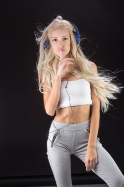 Kulaklığı ve telefonu olan genç bir kadın.