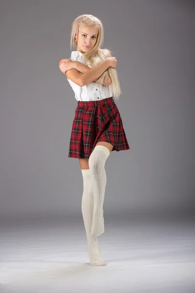 Stijlvol trendy blonde vrouw in wit overhemd en geruite rok — Stockfoto