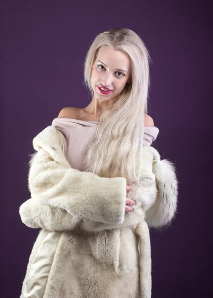 Mujer joven modelo de moda vestida con abrigo de piel blanca — Foto de Stock