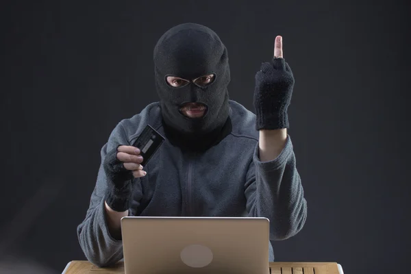 Хакер держит украденную кредитку — стоковое фото