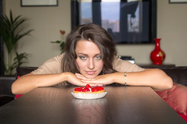 Chica bonita Buscando pastel de fresa — Foto de Stock