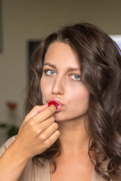 Vrouw eten thuis cake met frambozen — Stockfoto