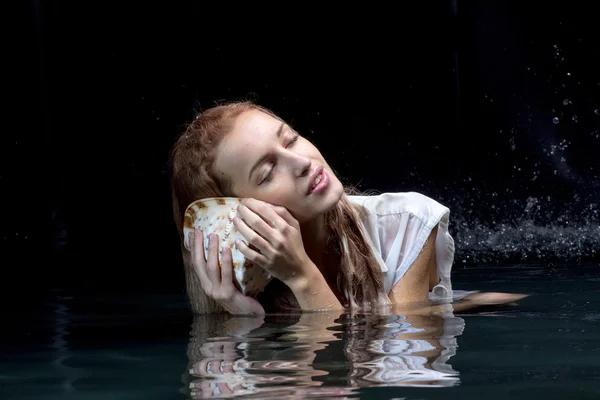 Frau mit Muschel im Wasser — Stockfoto