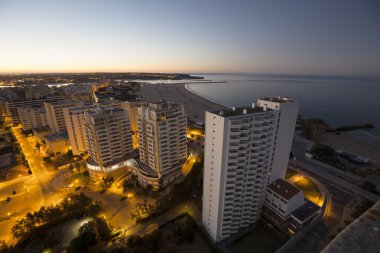 Otel ve bankanın gündoğumu sırasında okyanus plaj.